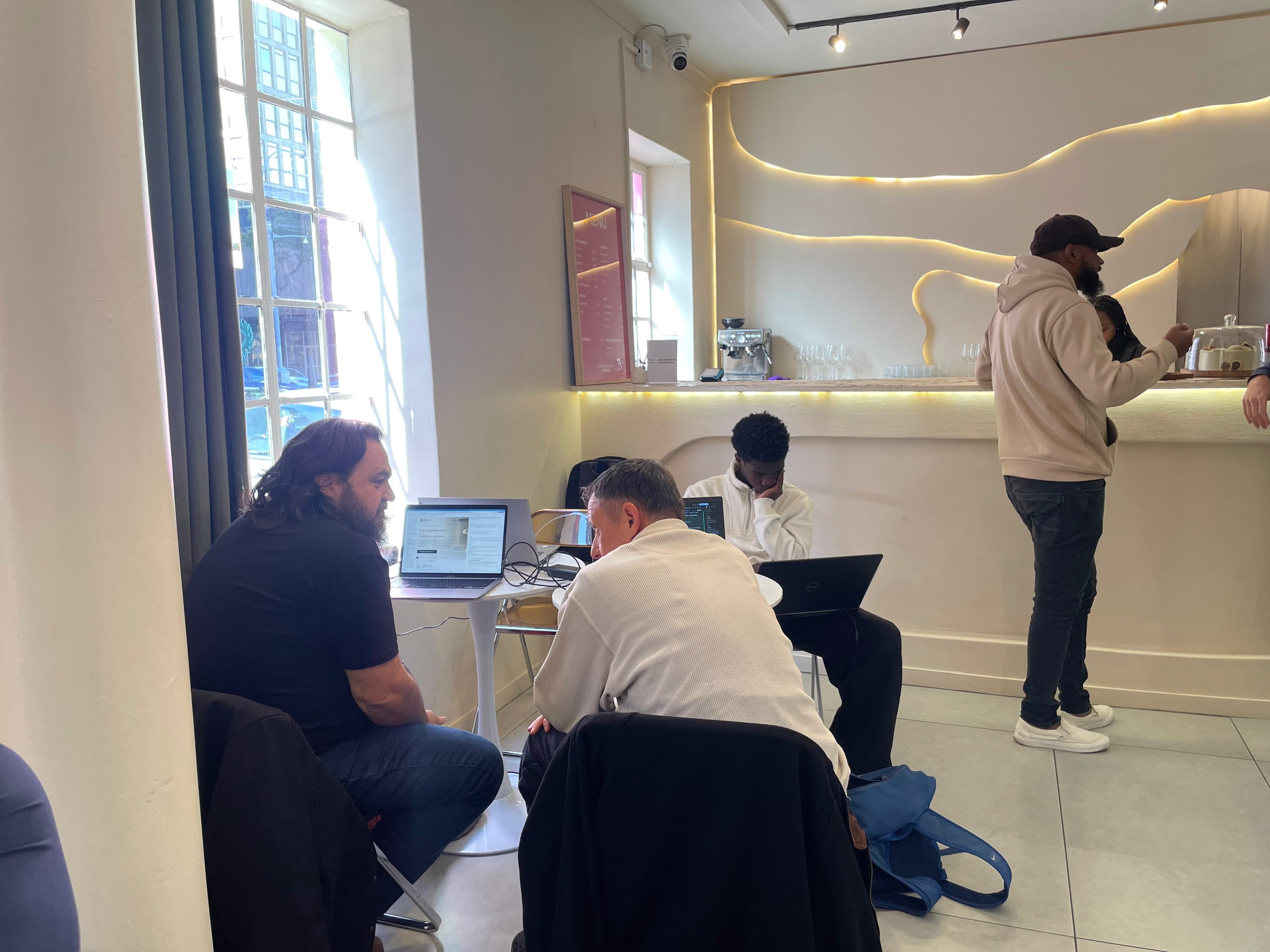 Builders working side by side at a table during the Cafe Cursor Johannesburg session